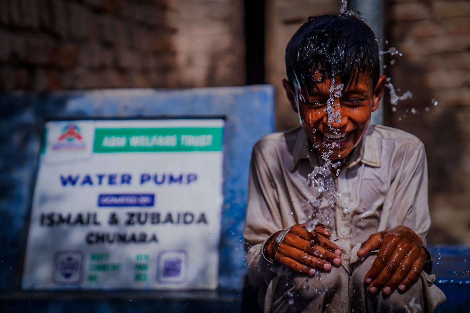 Child enjoying clean water from a community hand pump