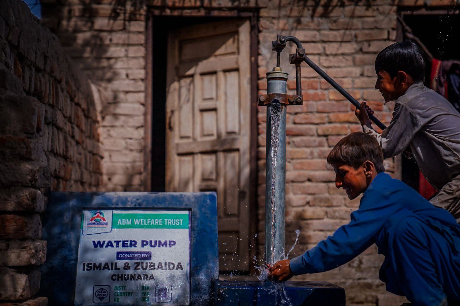 Children using donor funded clean water hand pump