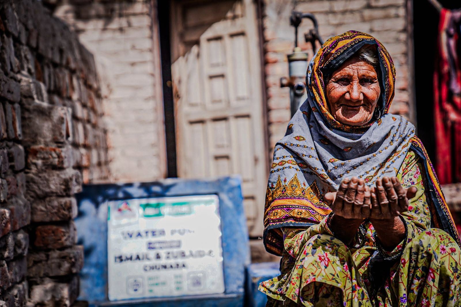 Elderly woman beneficiary at clean water pump
