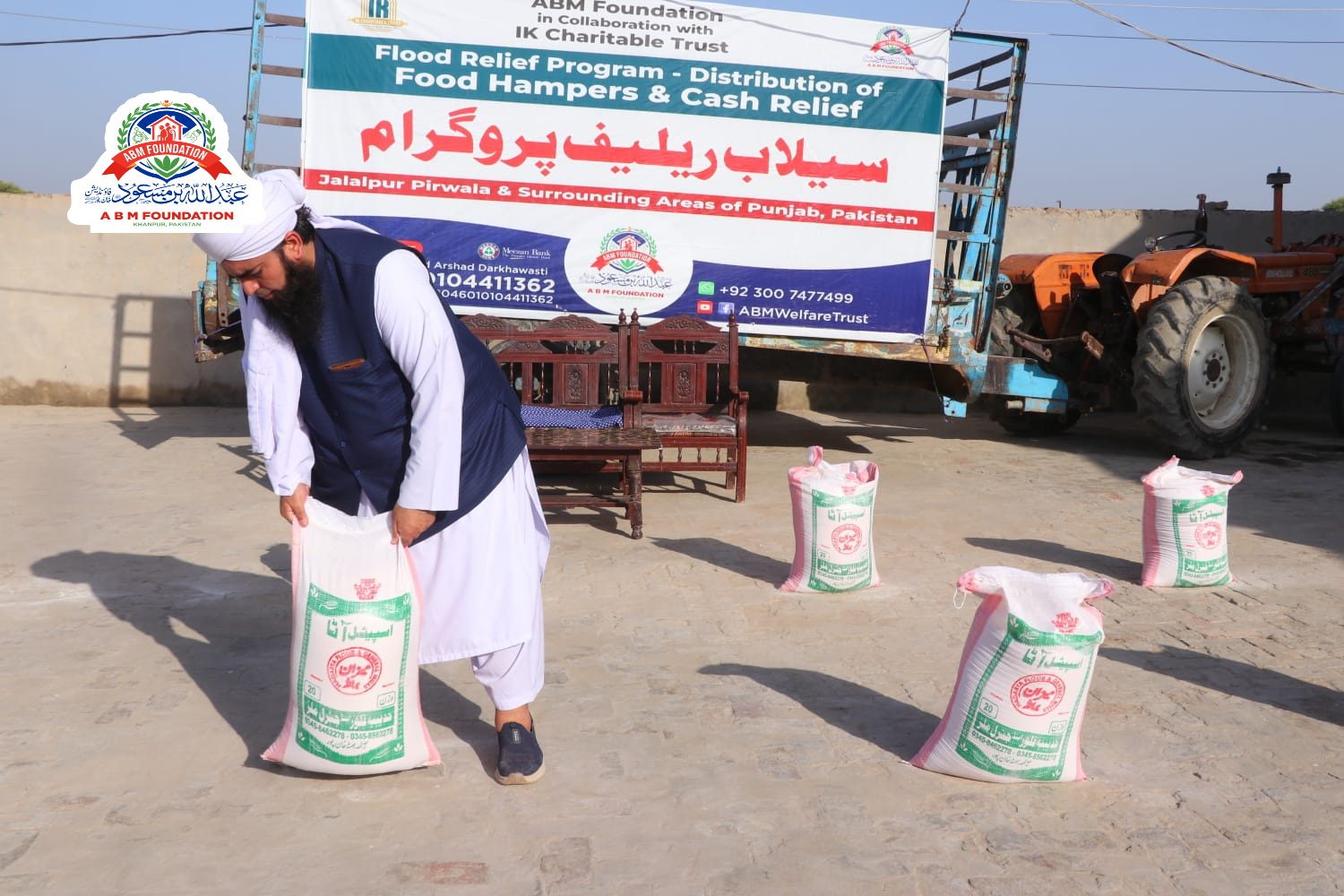 Flood relief food hampers beside delivery tractor