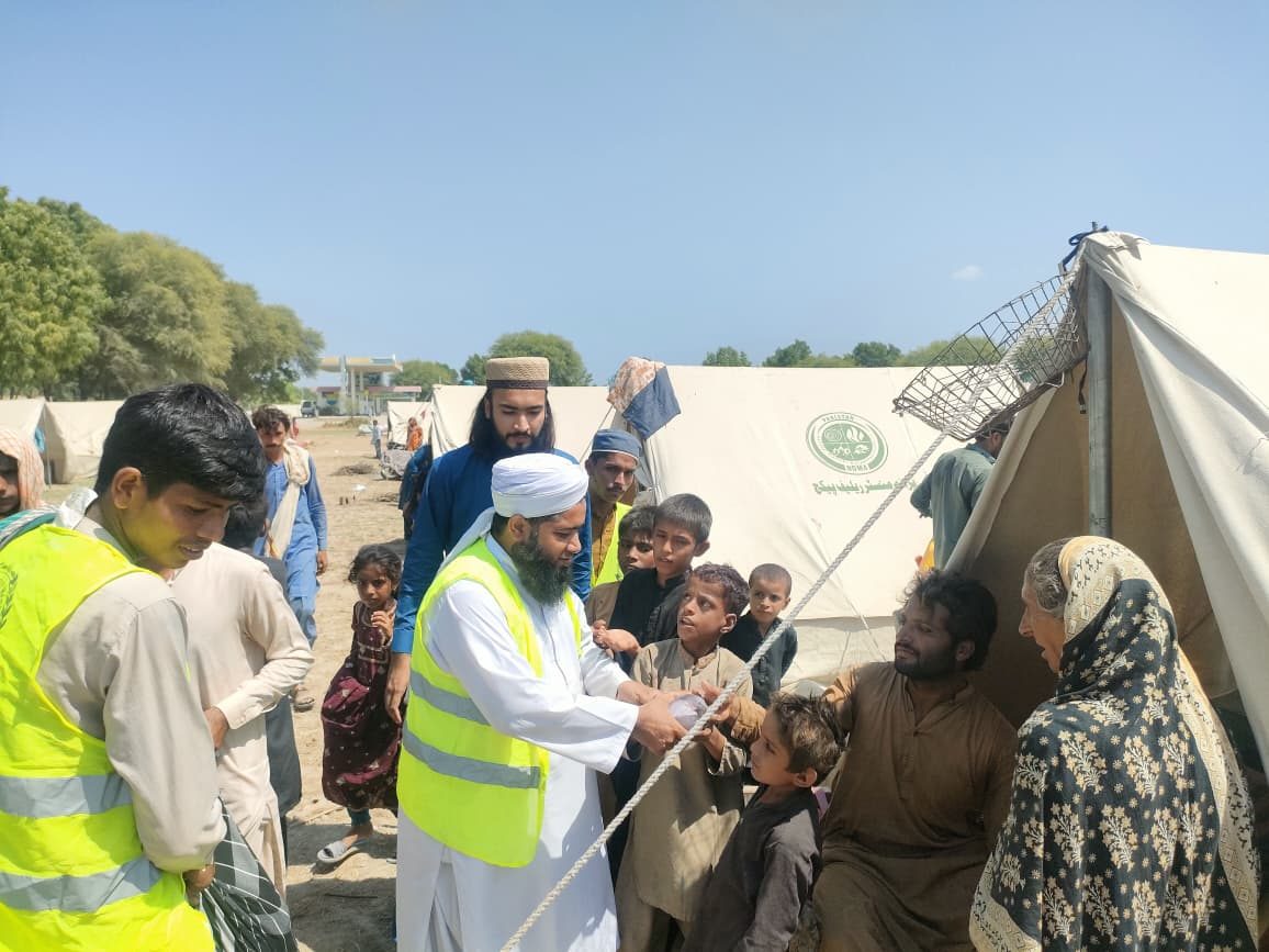 Flood relief team distributing meals at tent camp