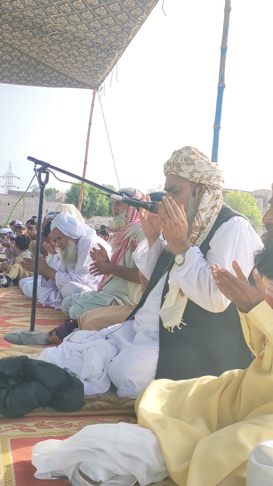 Religious scholar leading dua at community event
