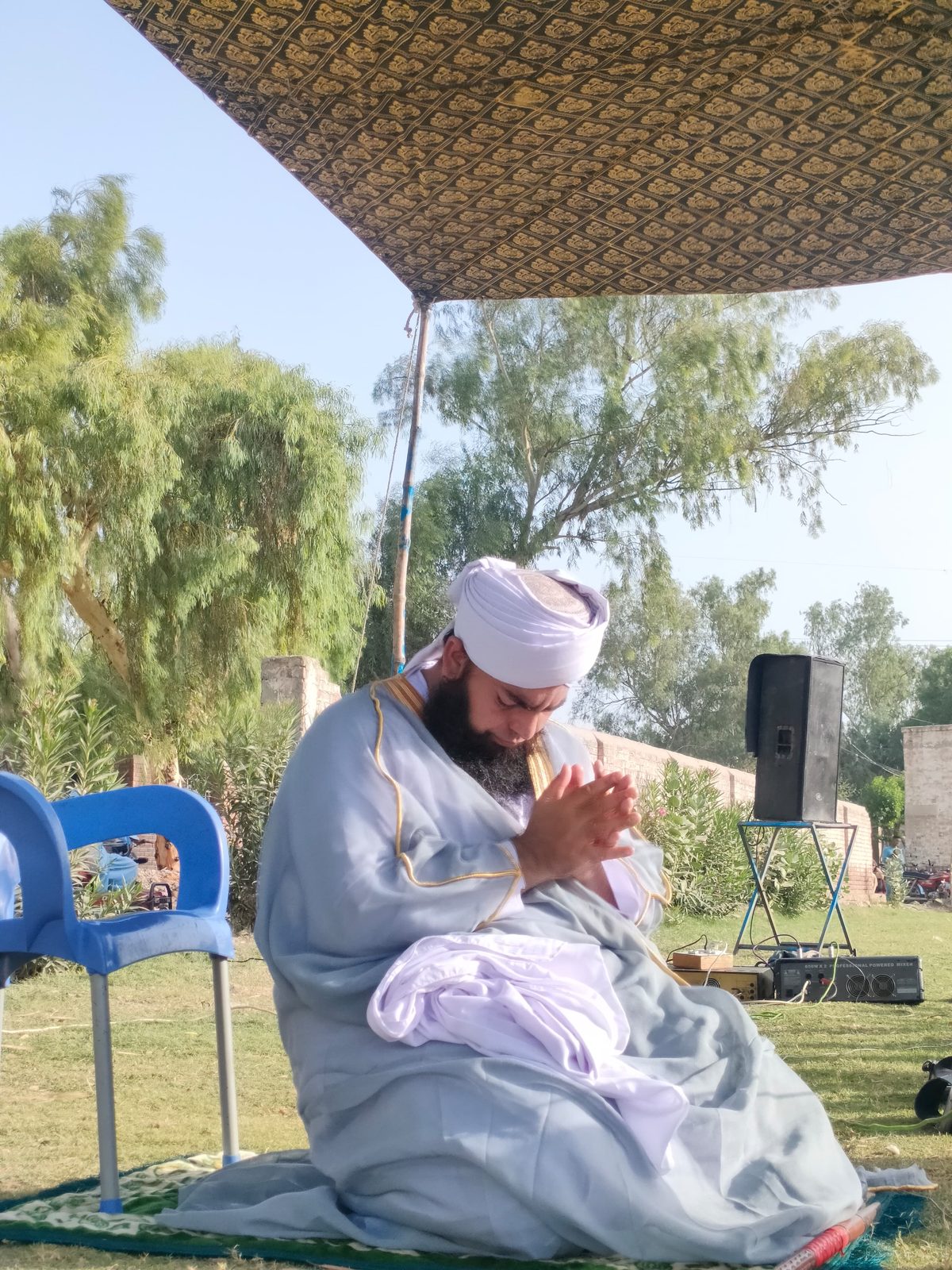 Religious scholar making dua at outdoor program