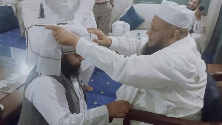 Religious scholar tying turban at ceremony