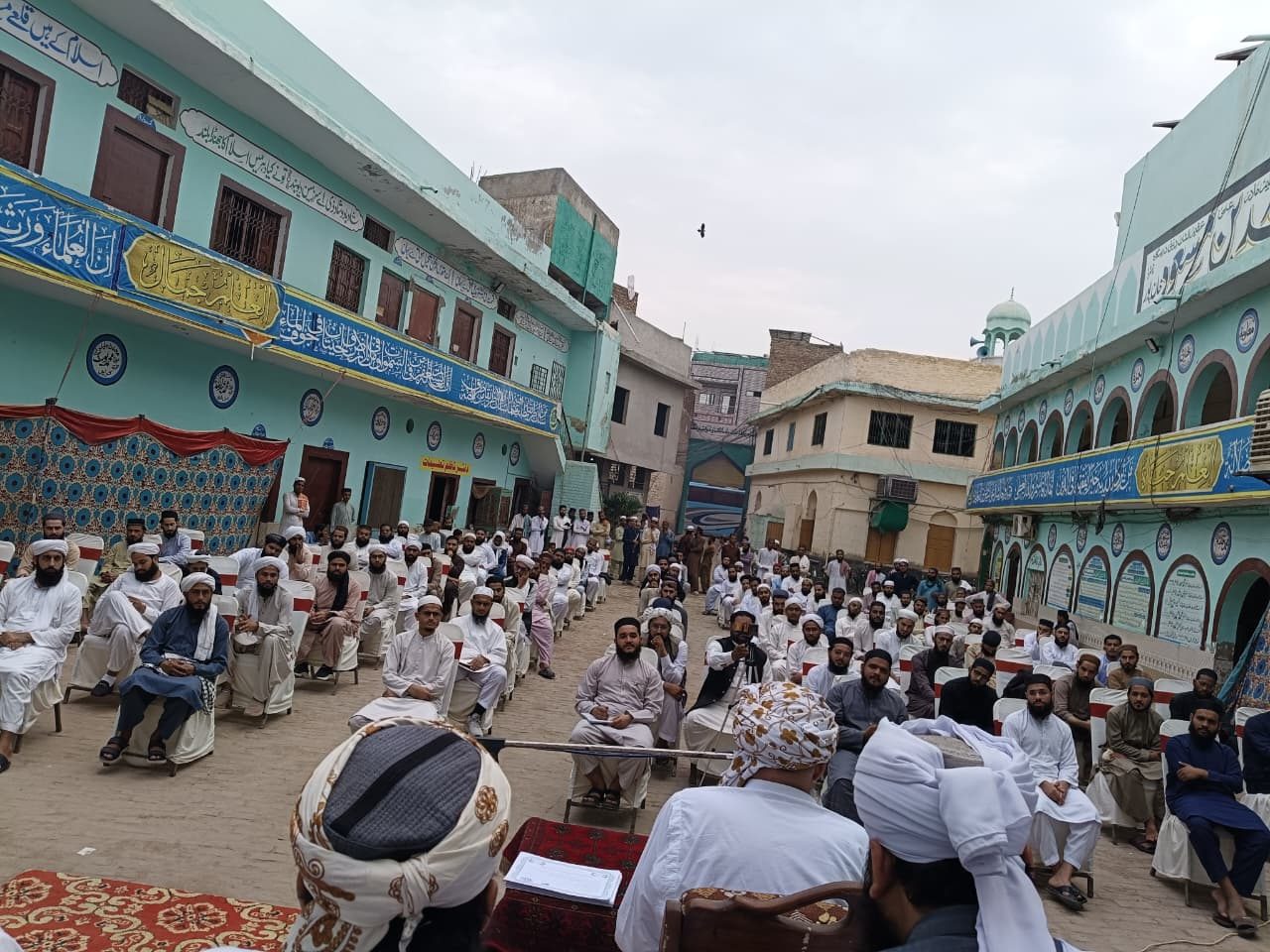 Religious scholars and students madrasa courtyard gathering