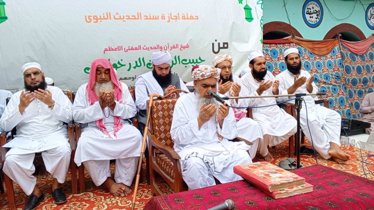 Religious scholars making collective dua on stage